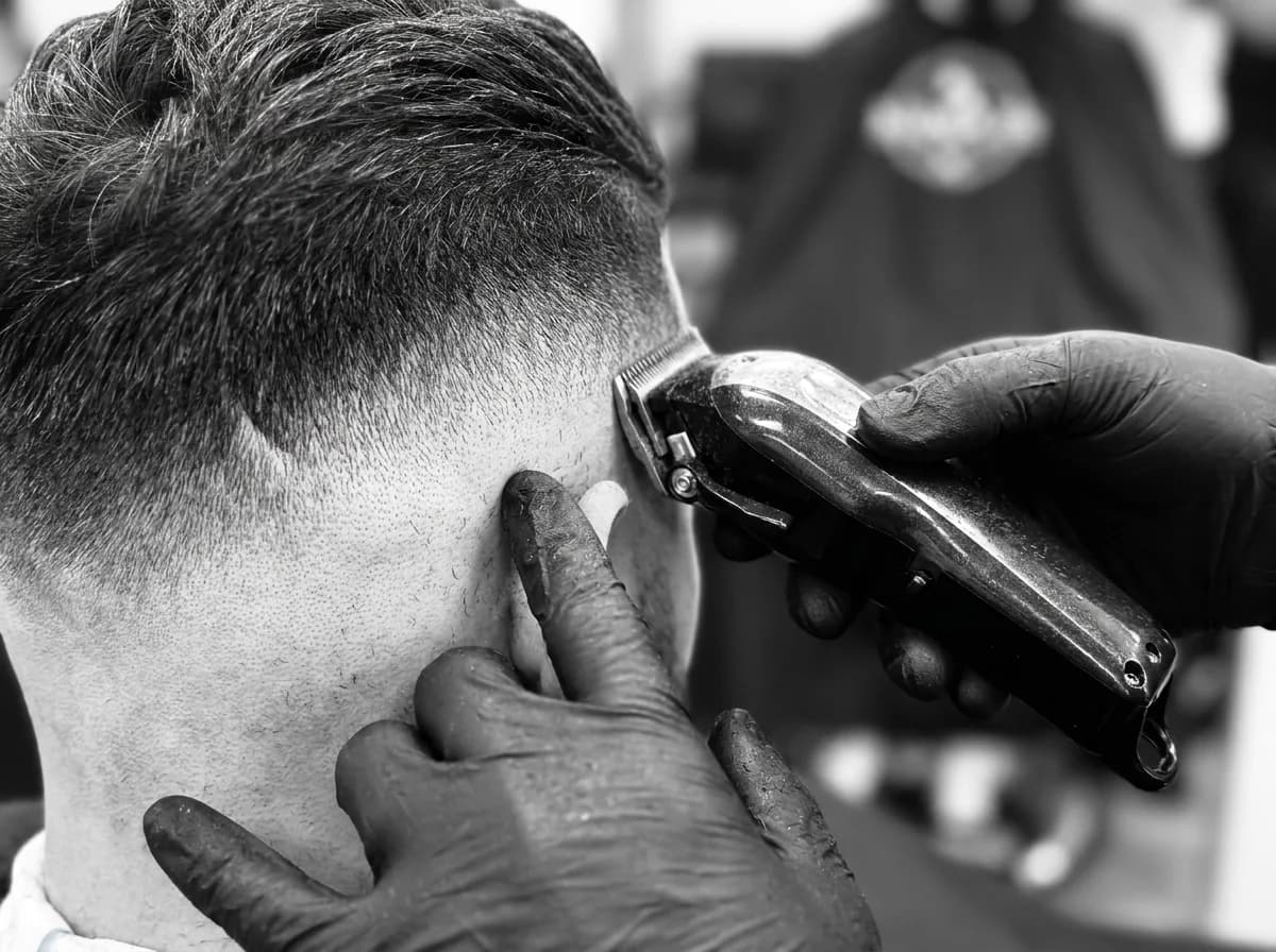 Close-up of a barber shaping a client's hair with scissors and comb